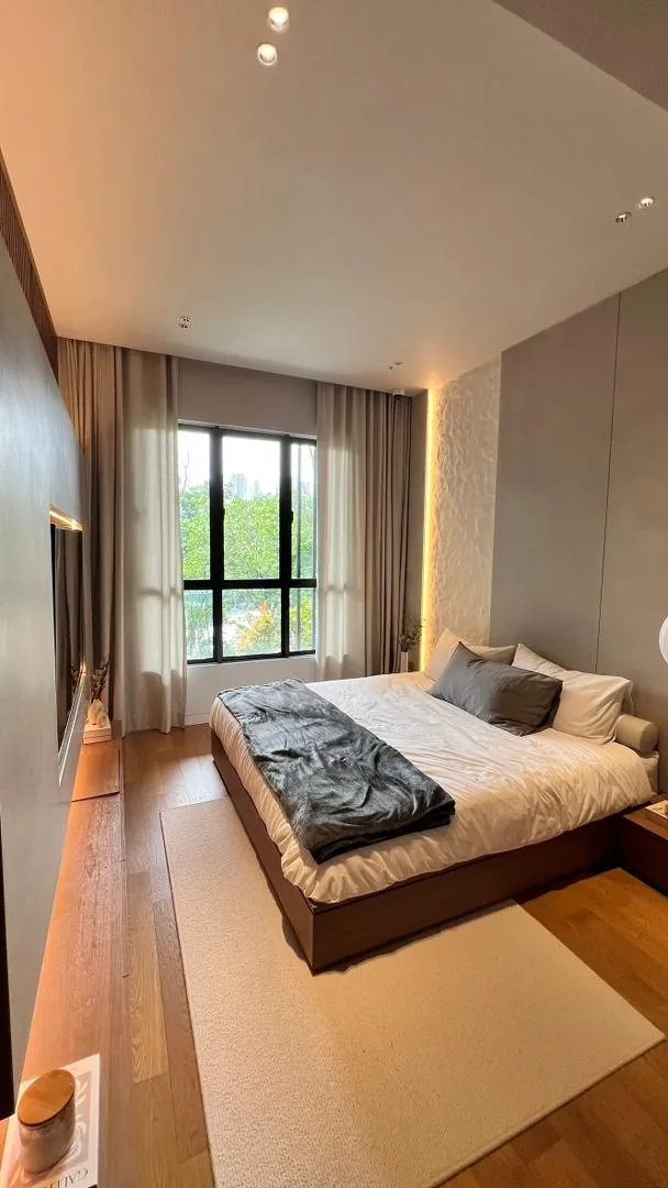 Amaya Residences show unit — bedroom with platform bed and greenery views
