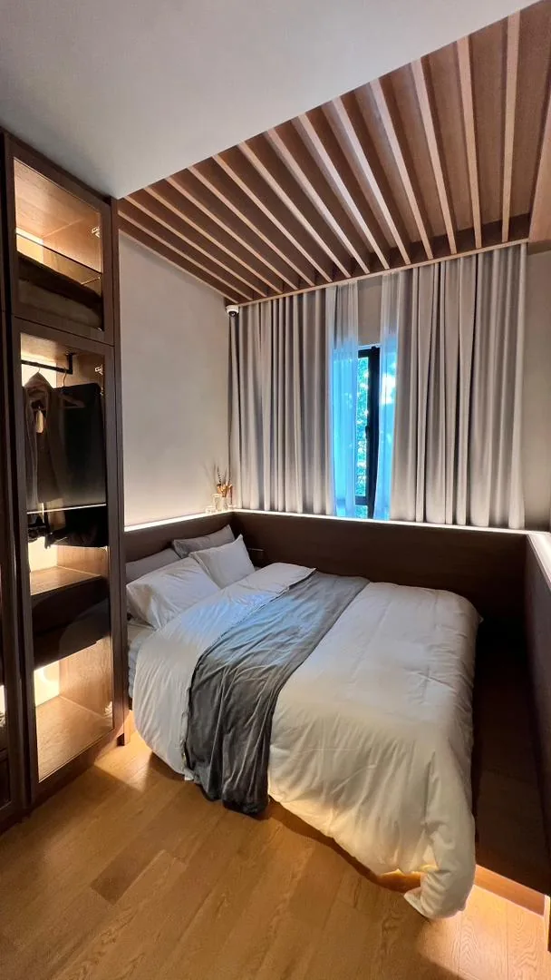 Amaya Residences show unit — bedroom with slatted timber ceiling and glass wardrobe
