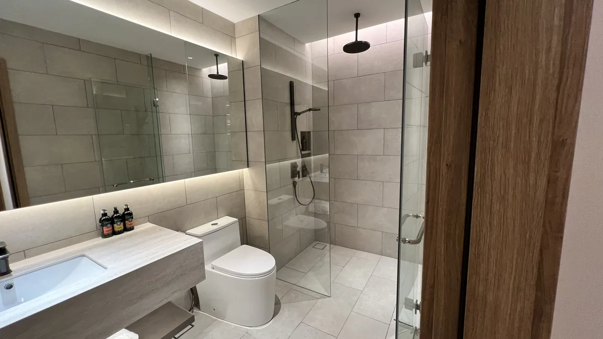 Armani Hallson show unit — bathroom with glass shower and double vanity
