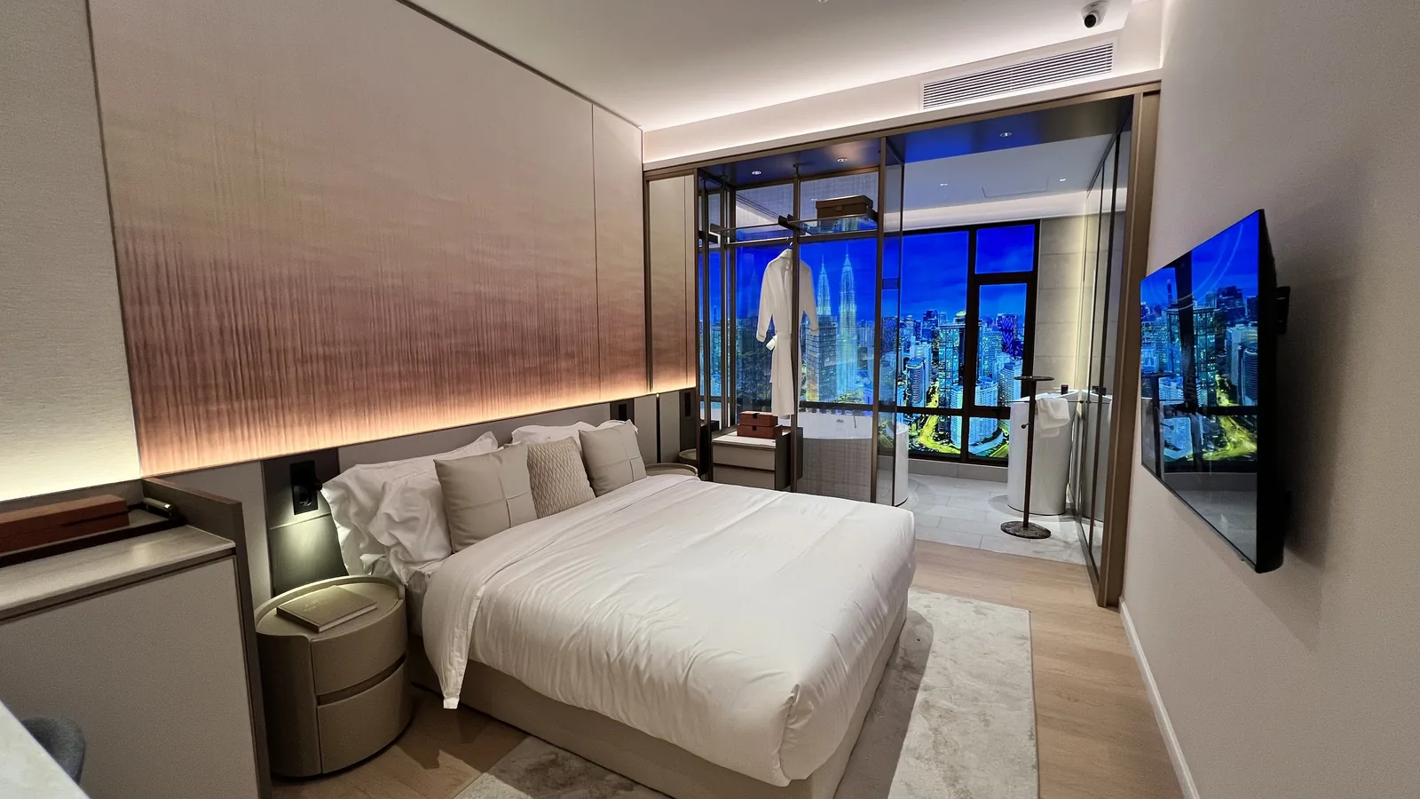 Armani Hallson show unit — bedroom with glass wall opening onto the KLCC skyline