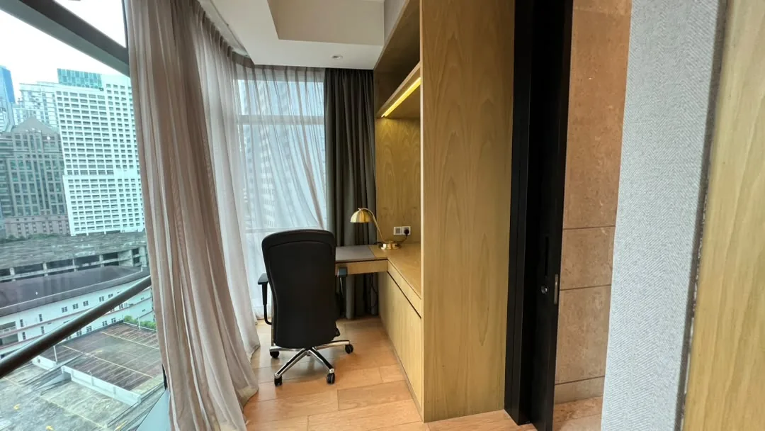 The Ritz-Carlton Residences Kuala Lumpur — study nook with built-in timber desk beside floor-to-ceiling windows overlooking the city